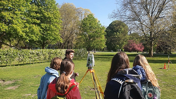Schülerinnen messen mit Tachymeter im Park